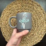 A gray cup with a written phrase on it / we remain (Palestine) made by hand