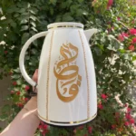 A luxurious white thermos adorned with the word "Qatar"